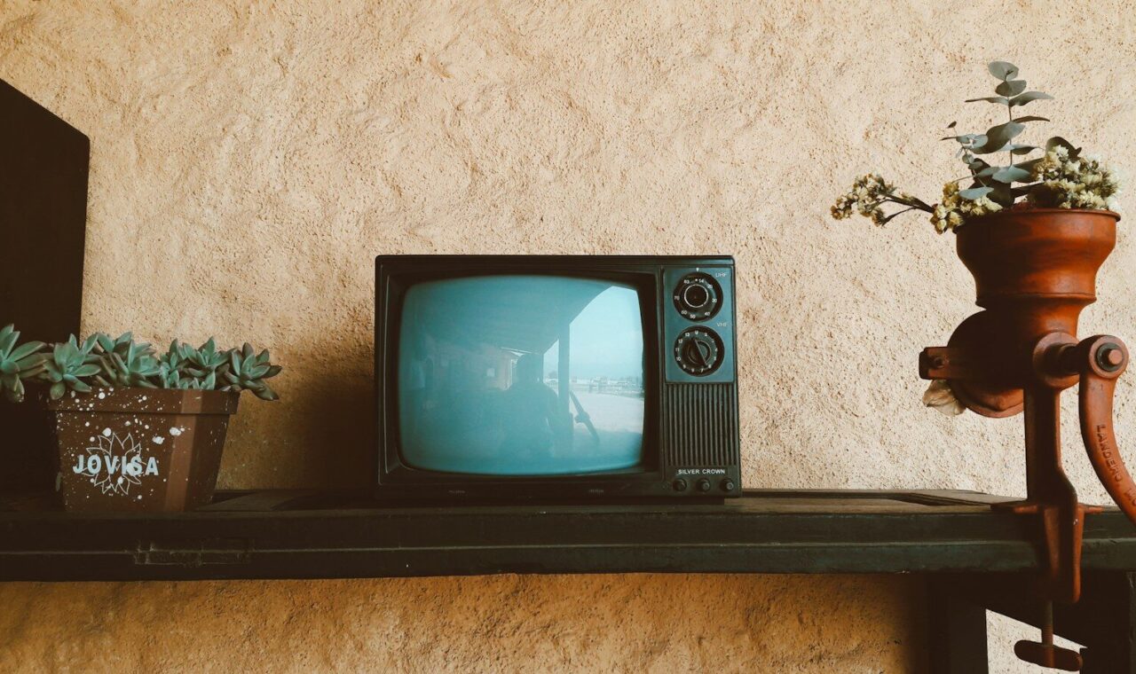 Televisor antiguo encendido sobre un mueble de madera