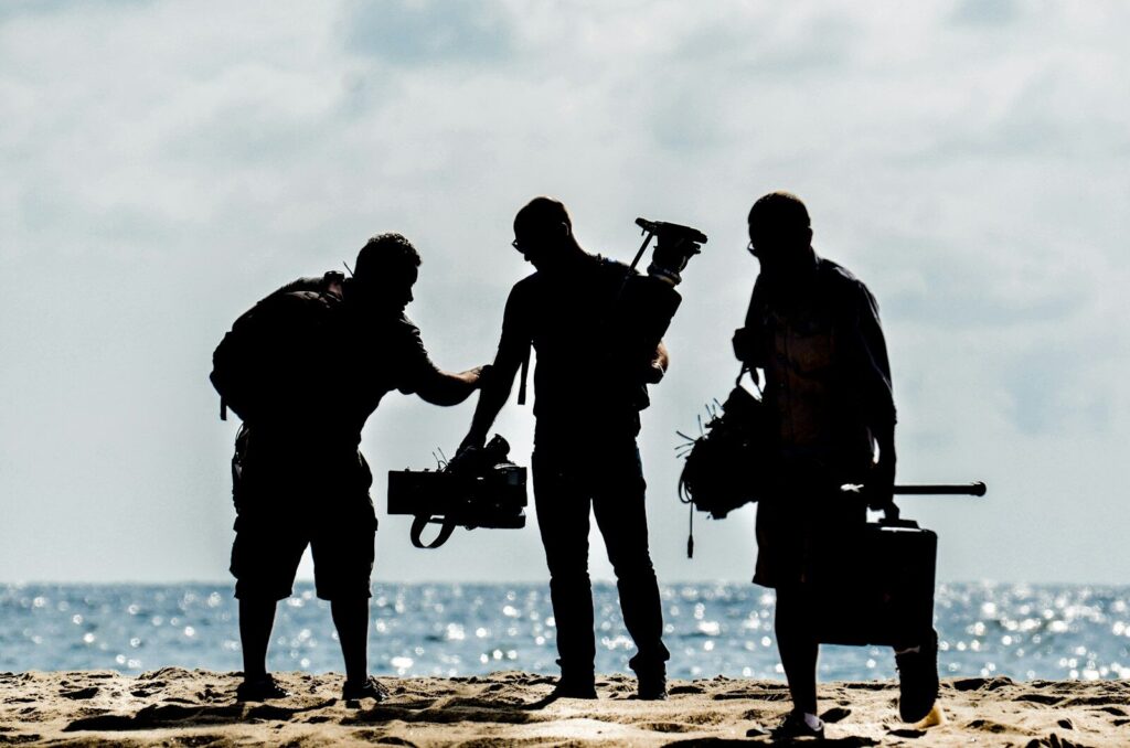 Equipo de rodaje de un cortometraje a contraluz en la orilla del mar